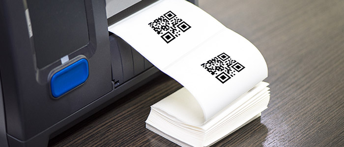 Impressora térmica imprimindo uma senha de atendimento em um balcão de varejo.