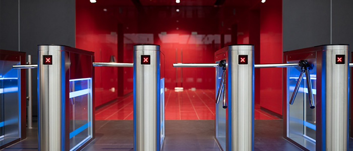 Pessoas passando por catracas modernas em um lobby de escritório